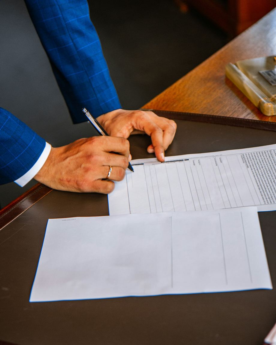 Persona revisando y firmando la documentación de una comunidad sobre un escritorio